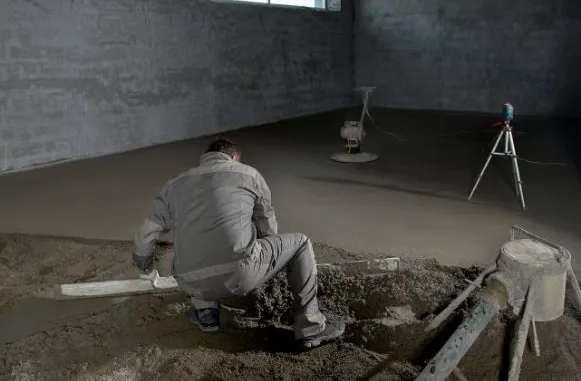 Робітники заливають бетонну плиту підлоги